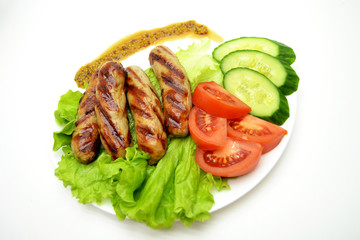 fried sausages and salad on a white plate