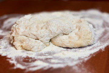 Dough for pizza. Rolling pin and dough on wooden background