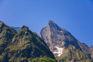 Obraz premium The tops of the mountains in the snow on a clear summer day. High in the Caucasian mountains, around dombai.