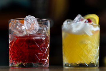 Glasses of cocktails on bar background