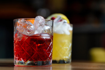 Glasses of cocktails on bar background