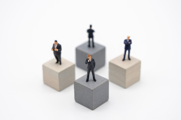 Miniature 4 people businessmen standing on Wooden cube Investment Analysis Or investment Blockchain concept. as background business concept and strategy concept with copy space.