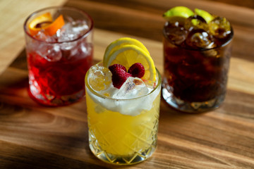 Glasses of cocktails on bar background