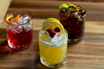 Glasses of cocktails on bar background
