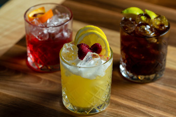 Glasses of cocktails on bar background