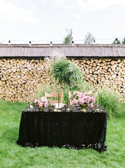 Elegant black and pink table setting for wedding reception with bouquets