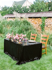 Elegant black and pink table setting for wedding reception with bouquets