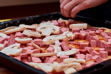 A variety of processed cold meat products, on a wooden cutting board
