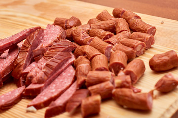 A variety of processed cold meat products, on a wooden cutting board