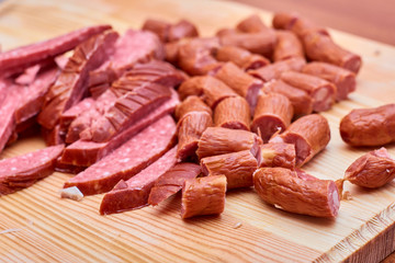 A variety of processed cold meat products, on a wooden cutting board