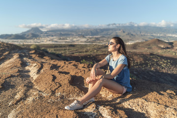 Fototapeta na wymiar Pretty tourist brunette girl relaxing near mountains.