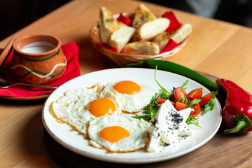 Fried eggs with cheese and tomatoes, breakfast