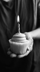 .woman's Hand Holding A  Cupcake with candle