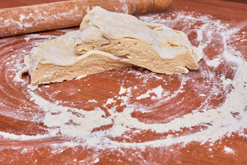 Dough for pizza on the wooden table, close-up. Dough for pizza.
