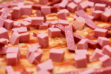A variety of processed cold meat products, on a wooden cutting board