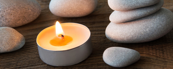 Stones and candle decoration against wooden background