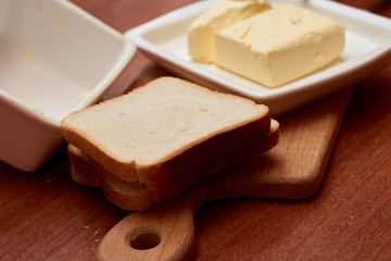 Piece of butter on white plate with knife