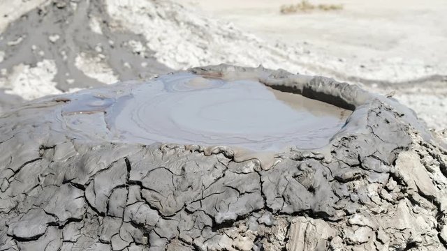 Crater of mud volcano bursting bubbles with natural gas. Famous nature landmark of Gobustan area near Baku in Azerbaijan