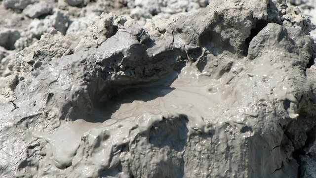 Crater of mud volcano bursting bubbles with natural gas. Famous nature landmark of Gobustan area near Baku in Azerbaijan