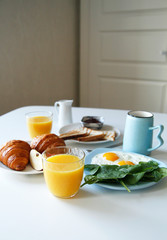 Fototapeta na wymiar breakfast. side view. light background. scrambled eggs, orange juice, toast, jam, croissants, coffee, milk, morning, close up