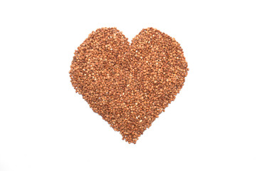 Buckwheat on a white background laid out in the form of a heart.