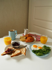 breakfast. side view. light background. scrambled eggs, orange juice, toast, jam, croissants, coffee, milk, morning, close up