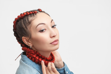 Braided hairstyle with red hair extensions on a white background