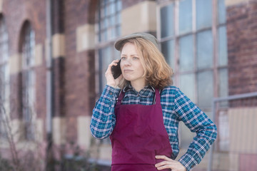 junge Frau mit Kappe und Schürze telefonierend