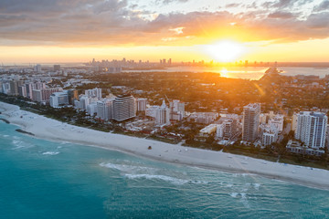 Miami Beach coastline at dusk. Amazing sunset view from helicopter. Skyscrapers and buildings