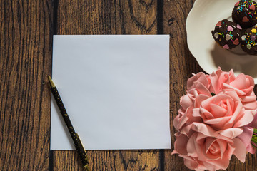 card with roses on wooden background