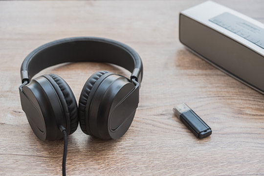 Black headphone,music player and thum drive put on wooden foor.