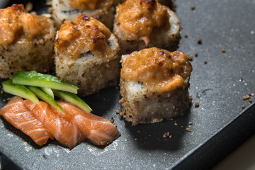 Japanese sushi rolls on a black frying pan. close view