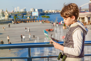 Cute young boy wandering around on city streets