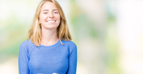 Beautiful young woman wearing blue sweater over isolated background Smiling with hands palms together receiving or giving gesture. Hold and protection