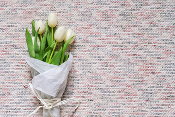 Bouquet of white tulips on textile background