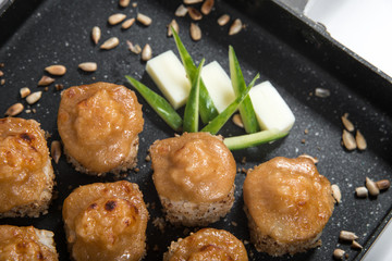 Japanese sushi rolls on a black frying pan. close view