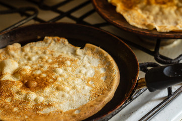 Thin pancakes in a pan on the stove