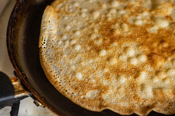 Thin pancakes in a pan on the stove