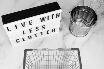 live with less clutter message on lightbox with shopping basket and trash bin