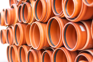 Orange PVC tubes in storage, Plastic tubes, Background of PVC