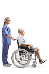 Fototapeta na wymiar Young female nurse pushing an elderly male patient in a wheelchair