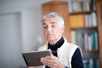 Ältere Frau zu Hause aktiv mit Tablet