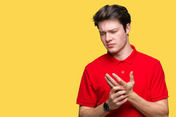 Young handsome man wearing red t-shirt over isolated background Suffering pain on hands and fingers, arthritis inflammation