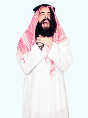 Arabian business man with long hair wearing traditional keffiyeh scarf shouting and suffocate because painful strangle. Health problem. Asphyxiate and suicide concept.