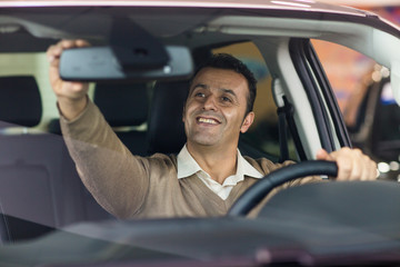 Obraz premium Handsome mature man sitting in his new car