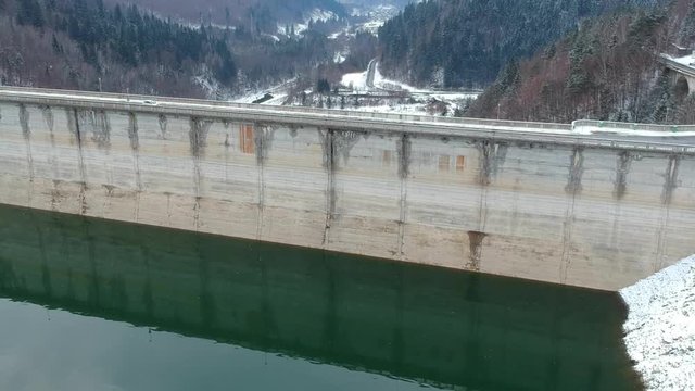 Lake Bicaz, Romania, in winter with snow aerial views, flight over the dam