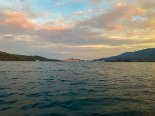 view from the yacht to the island with the traditional architecture in the Greek style