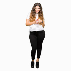 Young beautiful woman wearing casual white t-shirt Hands together and fingers crossed smiling relaxed and cheerful. Success and optimistic