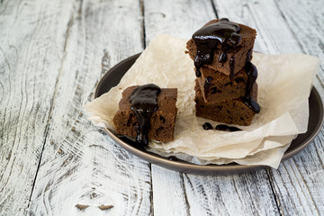 Chocolate Brownie on paper on white-brown rustic background with copy space