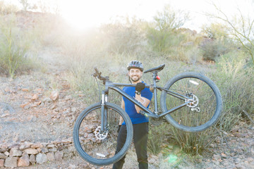 Fototapeta na wymiar Happy Man Lifting Bicycle And Showing Strength